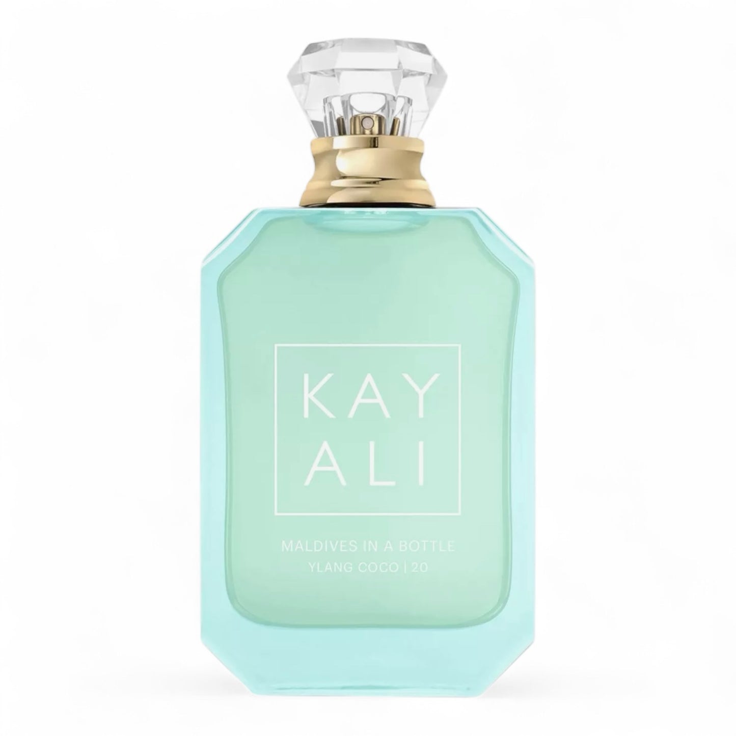 Kayali Maldives in a Bottle Ylang Coco | 20 sample surrounded by coconut halves, plumeria petals, and a tranquil ocean view.