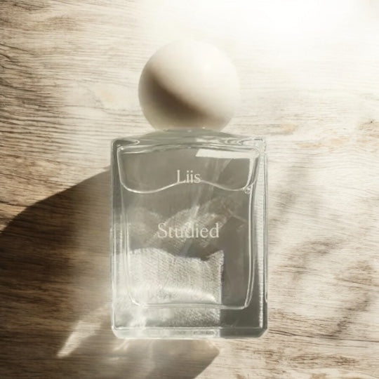 Close-up of a fragrance sample of Studied by Liis, highlighting its gentle blend of musky woods, airy florals, and comforting cashmere.