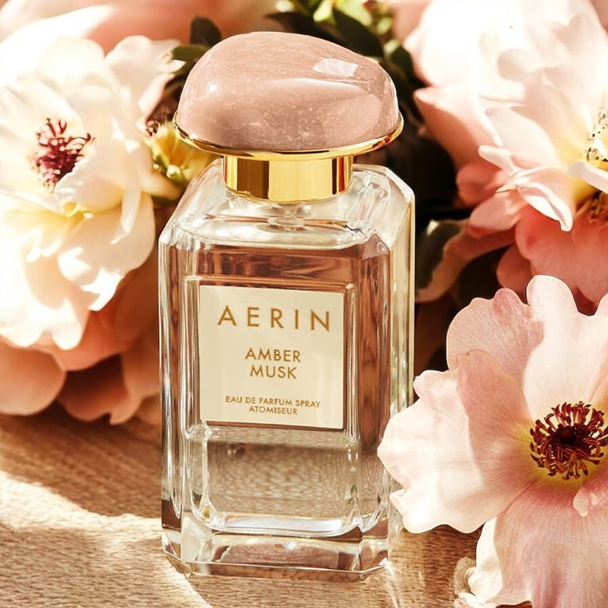 Aerin Amber Musk fragrance sample - warm amber and soft musk styled in an elegant floral setting.