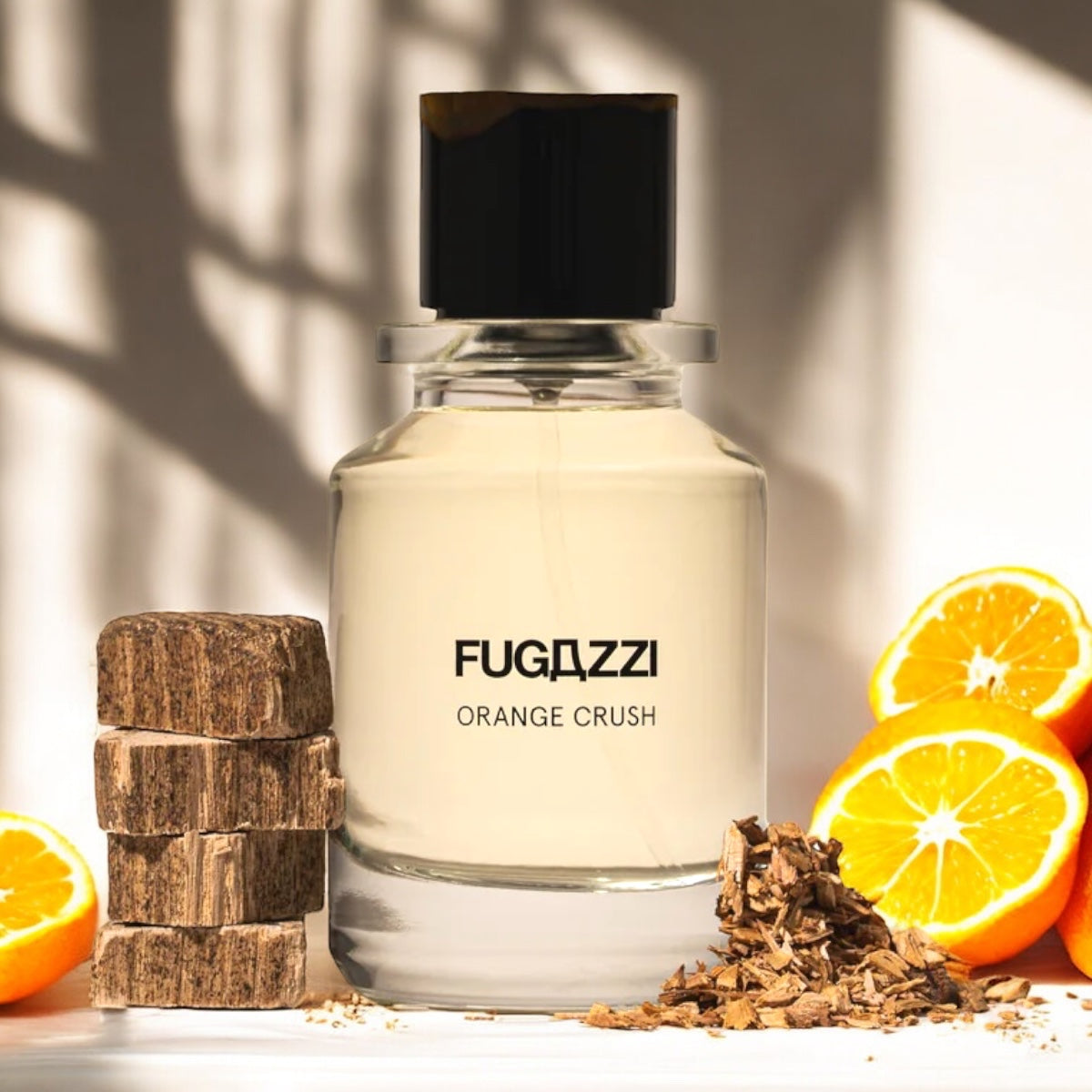 Fugazzi Orange Crush Extrait perfume sample - vibrant orange and woody extrait styled in a warm, modern setting with wood and orange slices