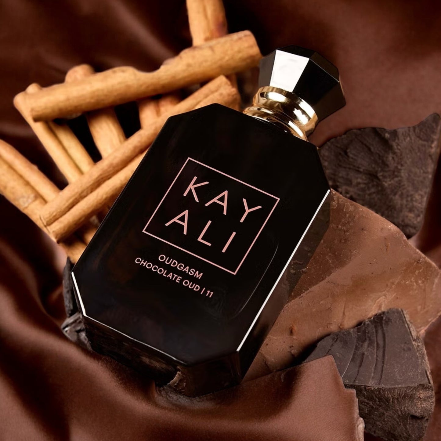 Kayali Chocolate Oud 11 fragrance sample – spiced apple, rum and warm woods styled in a rich lifestyle setting.