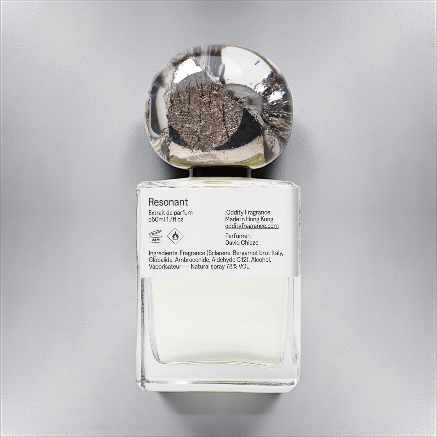 Oddity Resonant perfume sample – bright citrus, metallic, and ambergris notes styled in a cool, minimalist industrial setting.
