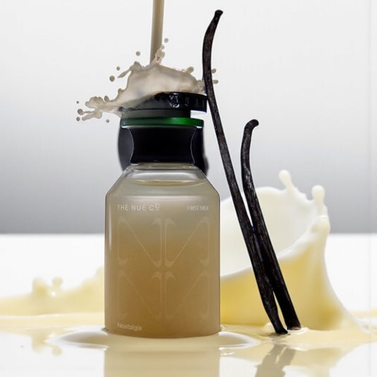 The Nue Co First Milk perfume sample – almond milk, vanilla and iris notes styled in a warm minimal setting.