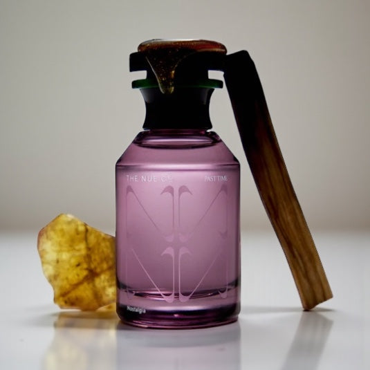 The Nue Co Past Time perfume sample – coconut milk, amber and sandalwood notes styled in a warm minimalist setting.