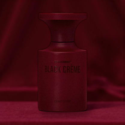BORNTOSTANDOUT Black Crème perfume bottle styled in a dark dimly lit burgundy velvet background