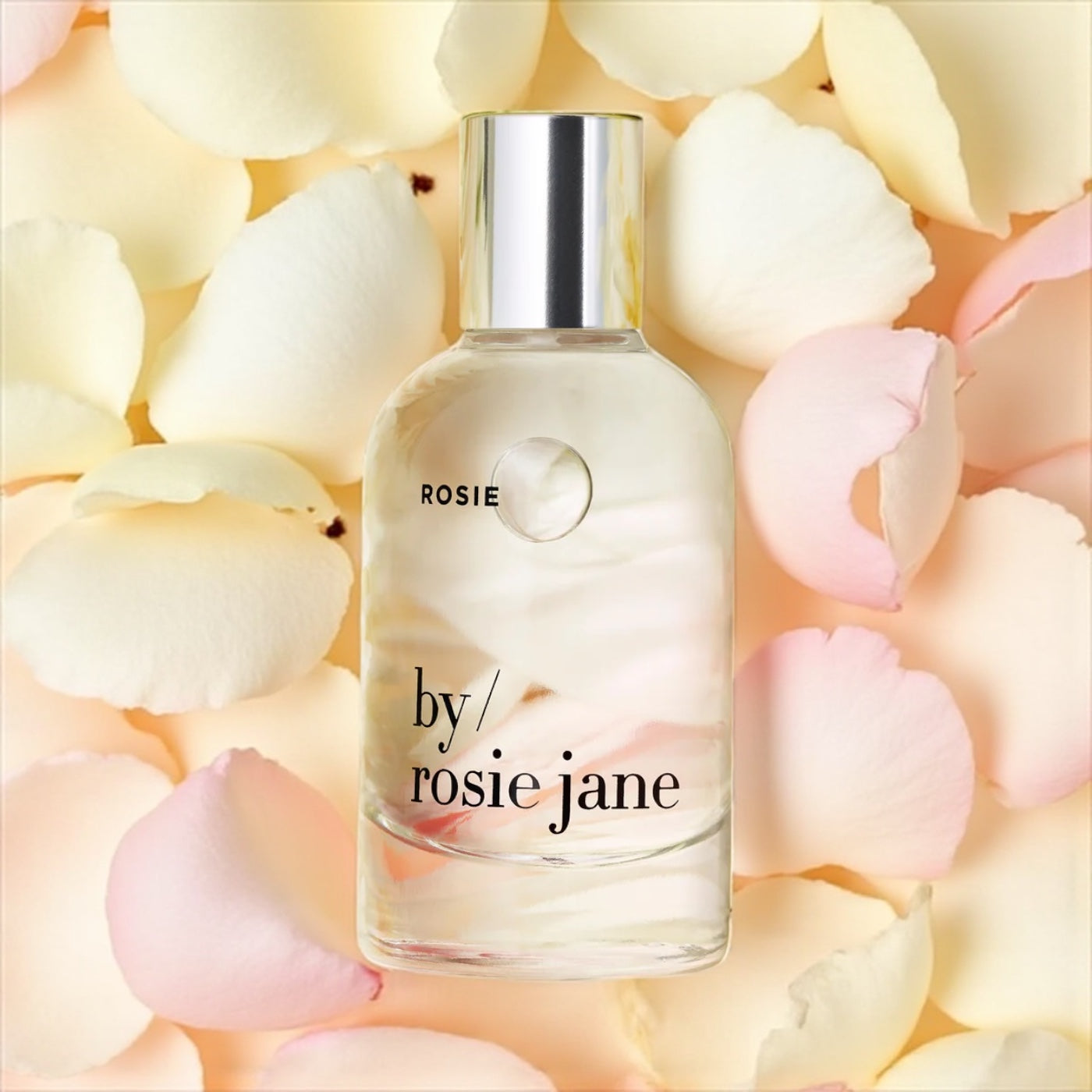 By Rosie Jane Rosie perfume sample – soft rose and white musk notes styled in a minimal rose petal setting.