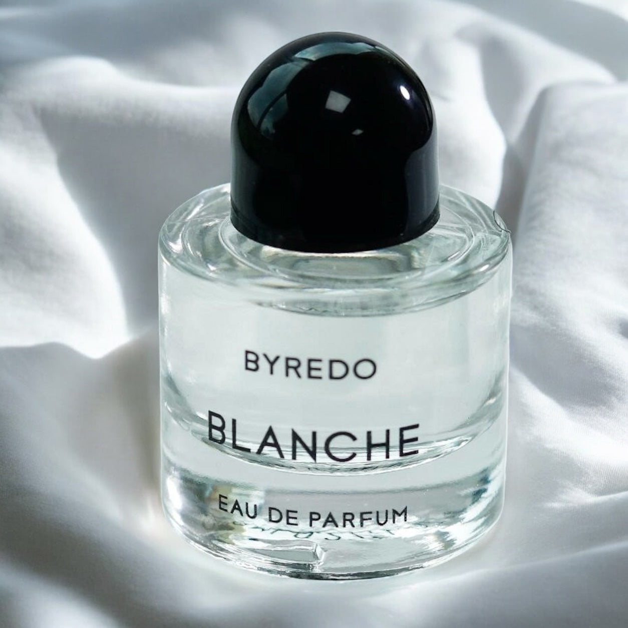 Byredo Blanche perfume sample – airy floral musk scent, styled on a fresh linen background evoking crisp, clean comfort.