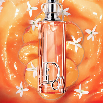 Dior Addict Peachy Glow perfume styled in a soft, vibrant peach-toned setting
