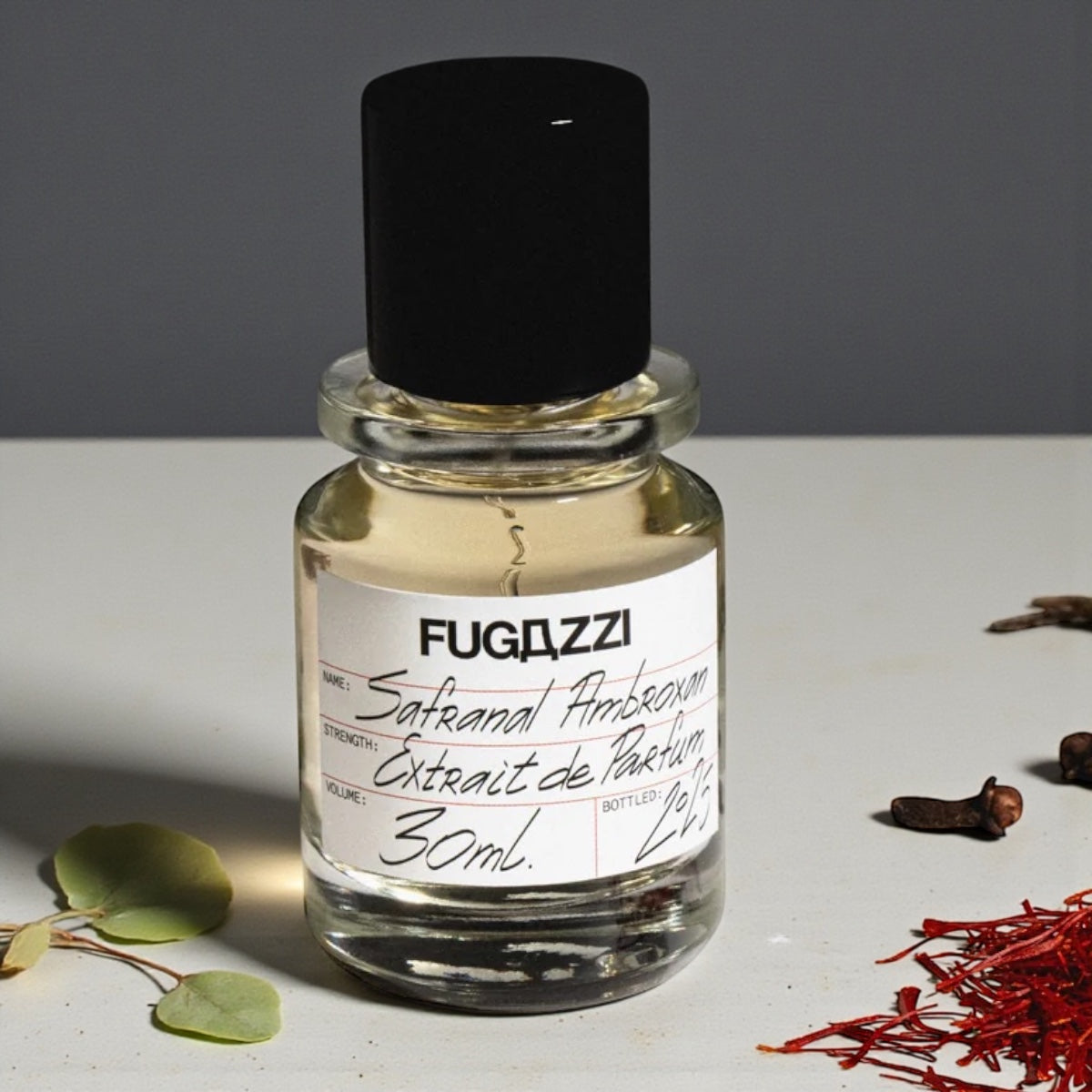 Fugazzi Safranal Ambroxan perfume sample styled with saffron threads and warm amber tones to highlight its rich spicy and woody character.