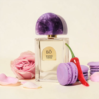 House of Bō Xuxú perfume styled in a vibrant elegant setting with rose, macarons and chilli pepper