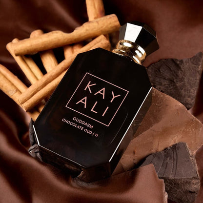 Kayali Chocolate Oud 11 fragrance sample – spiced apple, rum and warm woods styled in a rich lifestyle setting.