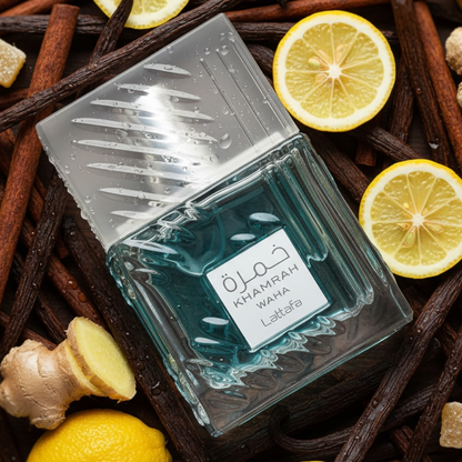 Perfume bottle labeled 'Khamrah Waha Lattafa' surrounded by lemons, cinnamon sticks, and ginger on a vanilla bean surface.