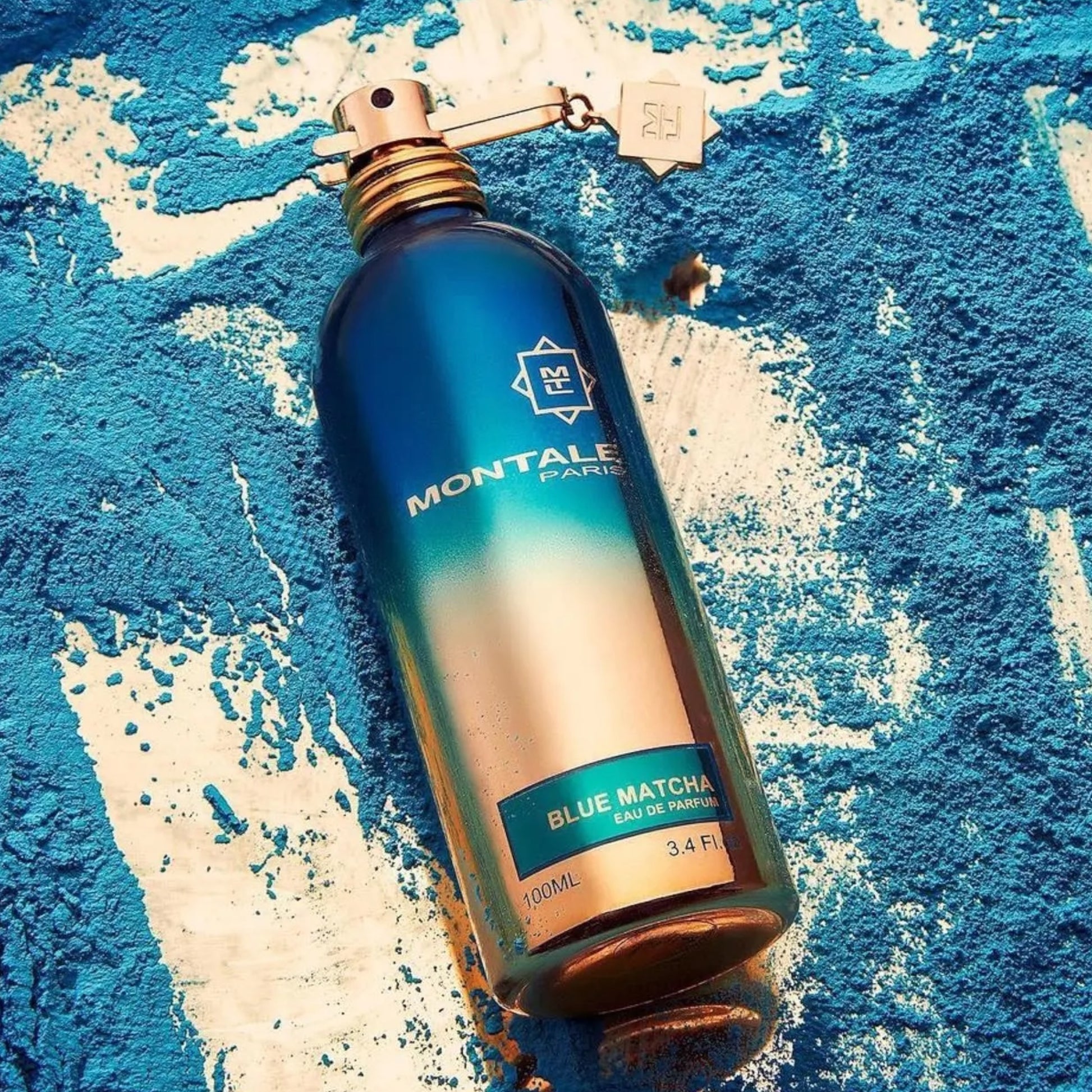 Montale Blue Matcha perfume sample - smoky matcha tea and woody leather fragrance styled in a blue matcha powder setting