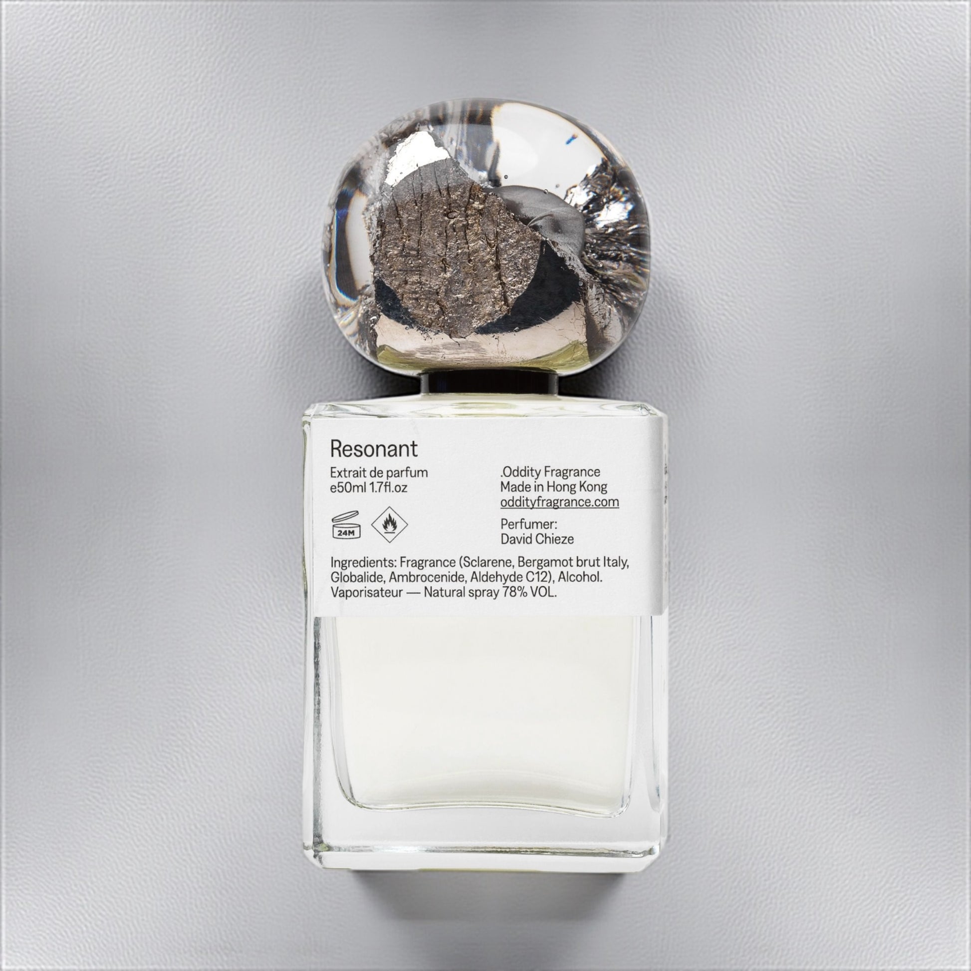 Oddity Resonant perfume sample – bright citrus, metallic, and ambergris notes styled in a cool, minimalist industrial setting.
