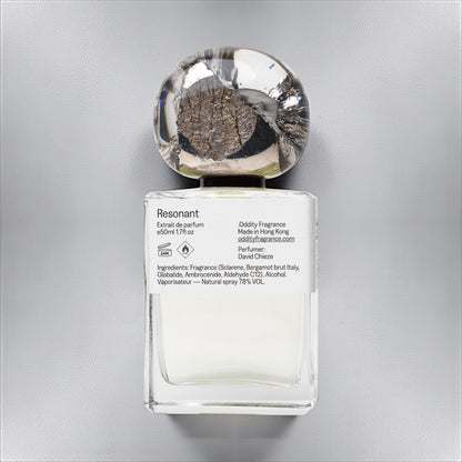 Oddity Resonant perfume sample – bright citrus, metallic, and ambergris notes styled in a cool, minimalist industrial setting.
