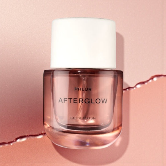 Phlur Afterglow perfume sample styled with soft warm light and apricot tones to reflect its fruity musk character.