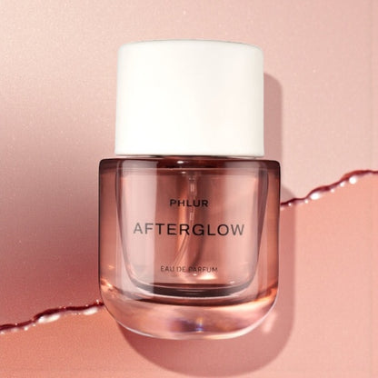 Phlur Afterglow perfume sample styled with soft warm light and apricot tones to reflect its fruity musk character.