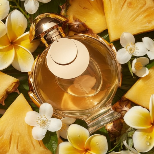 Rabanne Olympea Elixir perfume bottle styled with pineapple slices and jasmine and frangipani flowers
