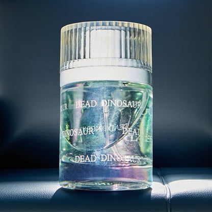 Snif Dead Dinosaur perfume sample – gasoline, amber woods, and pepper notes styled in a dark, moody setting.
