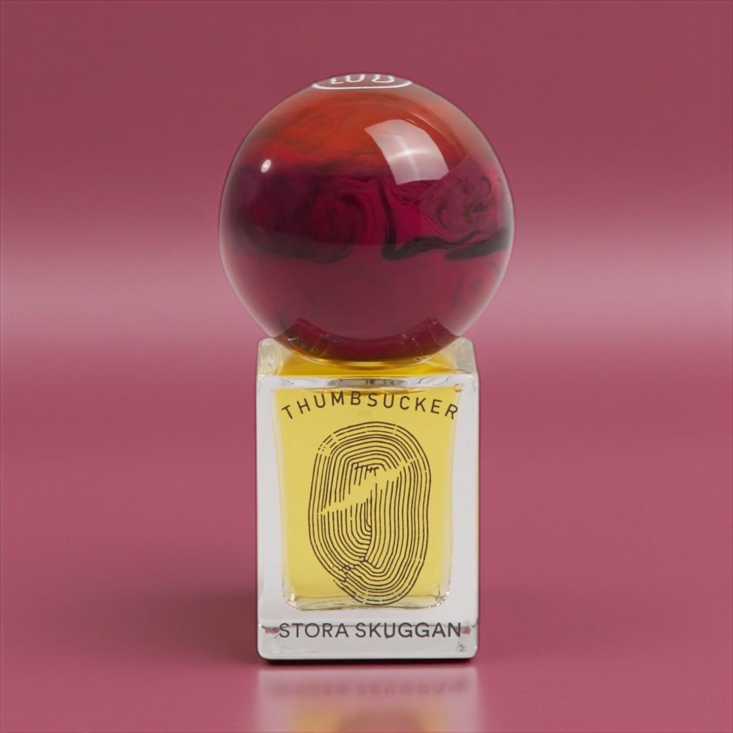 Stora Skuggan Thumbsucker perfume sample – honey, violet, and almond notes styled in a glowing amber and gold setting.