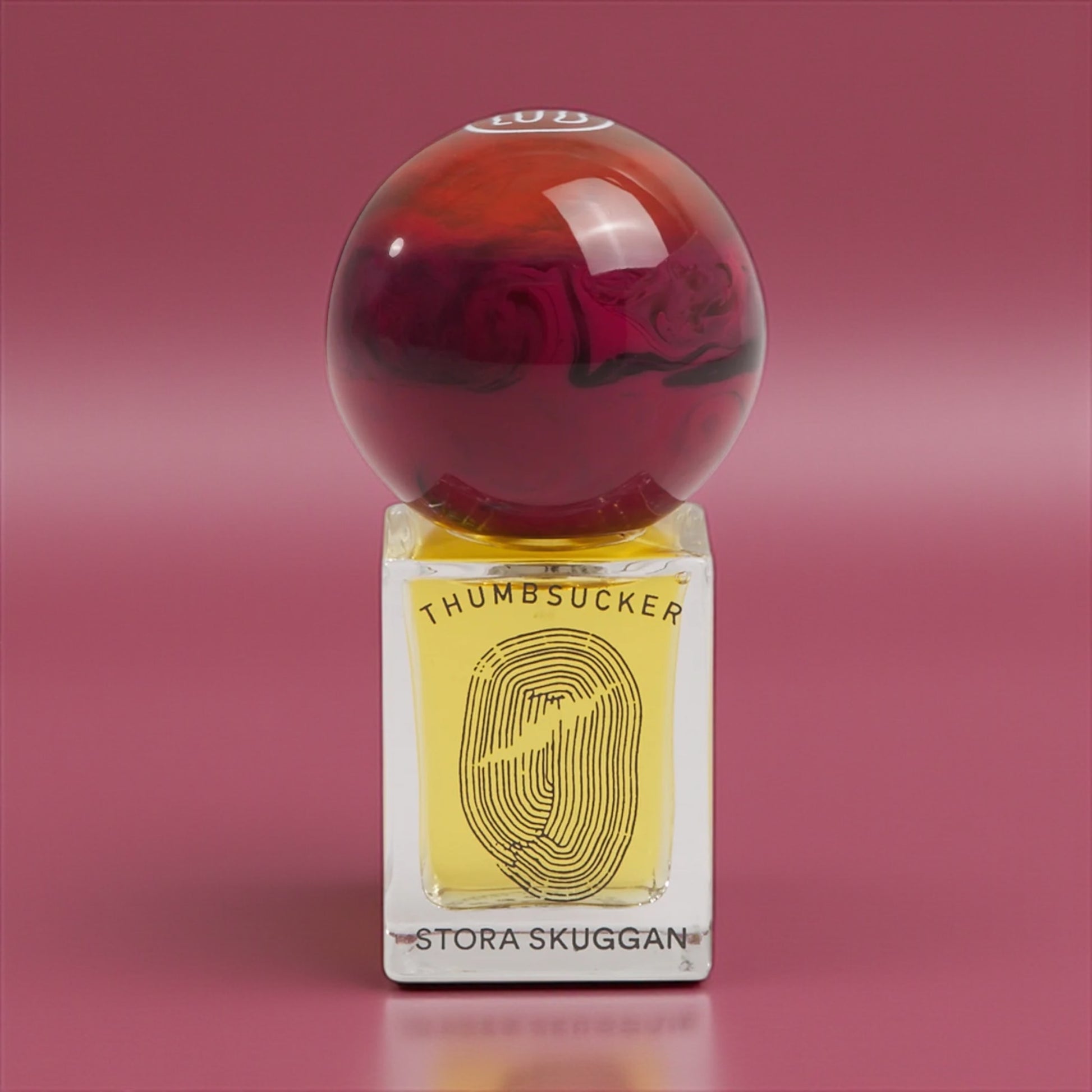 Stora Skuggan Thumbsucker perfume sample – honey, violet, and almond notes styled in a glowing amber and gold setting.